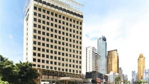 A high-rise hotel with a grid of windows, surrounded by other tall buildings. - Ambassador Hotel Shenzhen (Shenzhen)