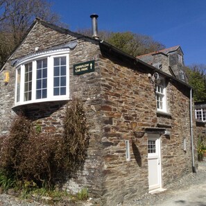 A stone building with a sign indicating an overflow car park. - The Mill House Inn (Tintagel)