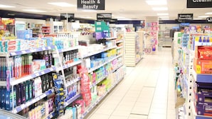 Un rayon de supermarché où, à gauche, se trouvent les produits de santé et de beauté, et à droite, les produits d’entretien.