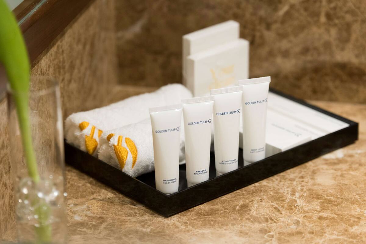 A tray with four tubes of Golden Tulip products and a towel with a yellow tulip design.