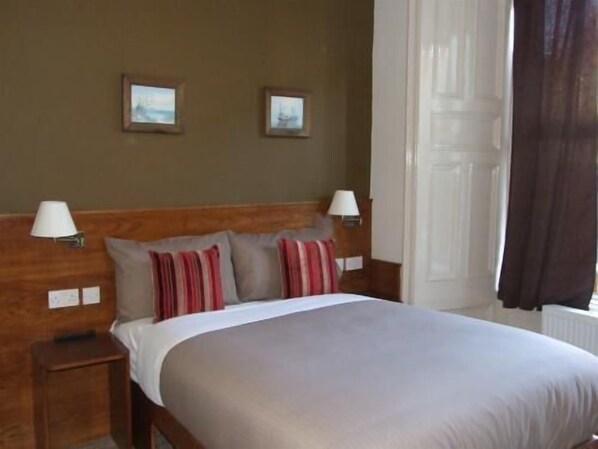 A hotel room with a bed, two bedside lamps, a nightstand, and two framed pictures on the wall. - Leith House (Edinburgh)