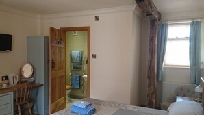 A bedroom with a bed, a desk, a mirror, and a wardrobe. - Church Farm (Solihull)