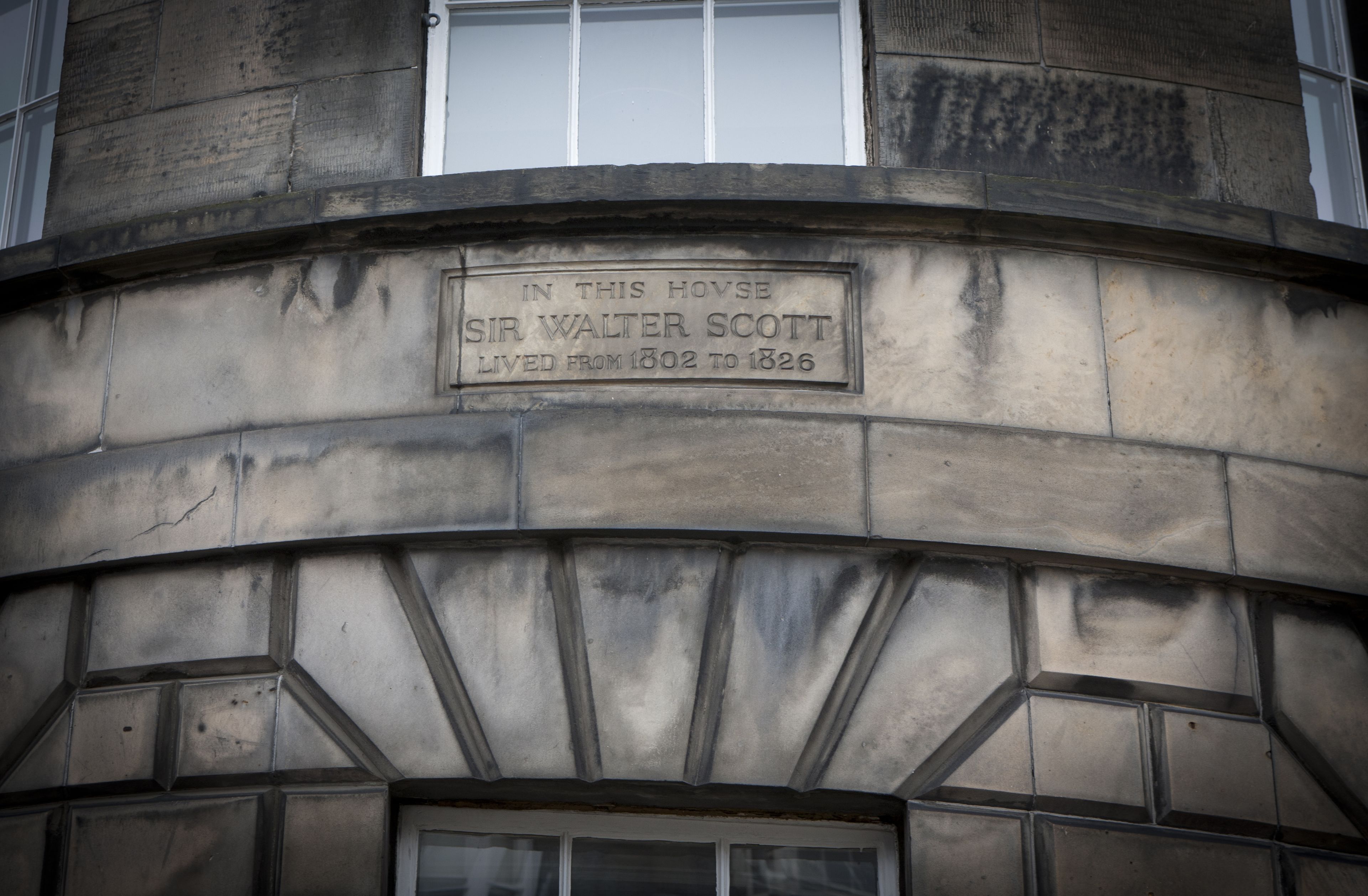 A stone plaque on a building with the inscription "IN THIS HOVSE SIR WALTER SCOTT LIVED FROM 1802 TO 1826."