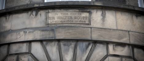 A stone plaque on a building with the inscription "IN THIS HOVSE SIR WALTER SCOTT LIVED FROM 1802 TO 1826."