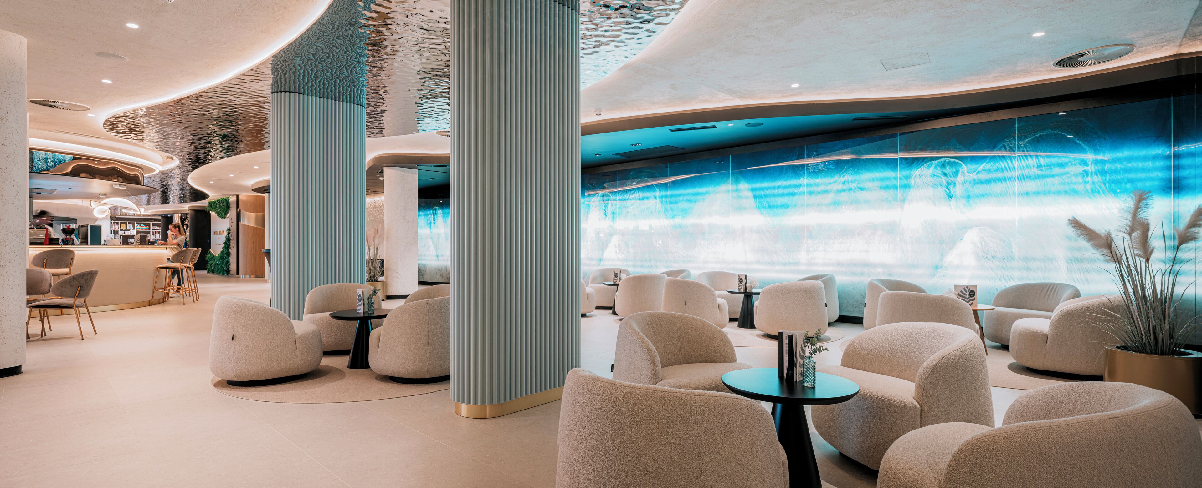 Een moderne lounge met comfortabele zitplaatsen, een waterpartij en uitzicht op de stad.