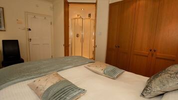Une chambre à coucher avec un lit, deux portes, une chaise et une armoire.