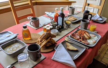 A breakfast table with various food items and condiments.