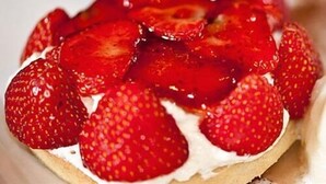 A dessert with strawberries and a yellow fruit on top. - The Greyhound Inn Aldbury (Tring)