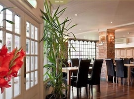 Un restaurante con techos altos, ventanas amplias y una combinación de elementos de madera y piedra.