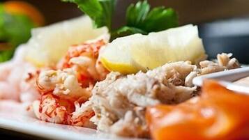 Un plato de mariscos, incluyendo camarones y cangrejo, adornado con perejil.