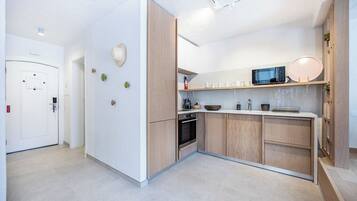 A modern kitchen with wooden cabinets, a microwave, and a built-in oven.