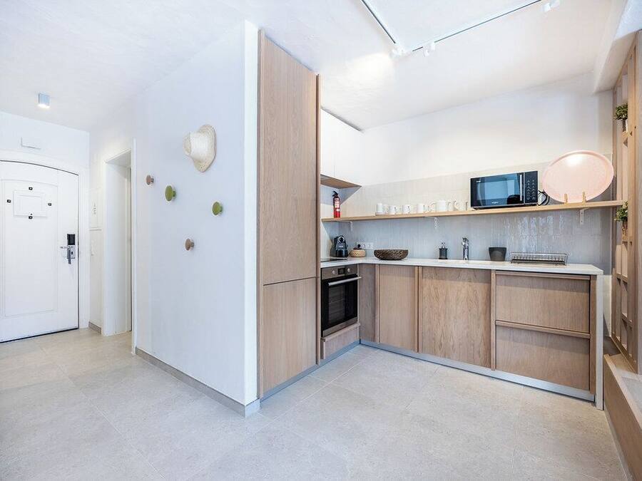 A modern kitchen with wooden cabinets, a microwave, and a built-in oven.