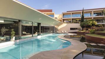 Una piscina cubierta, una piscina al aire libre de temporada, sombrillas