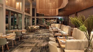 Un restaurant spacieux avec de hauts plafonds, des lustres modernes et différents types de sièges, notamment des tables et des banquettes.