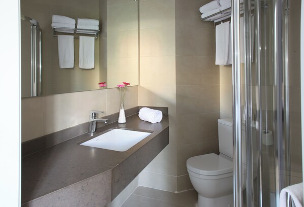A modern bathroom with a sink, mirror, and toilet. - MH Apartments Suites  (Barcelona)