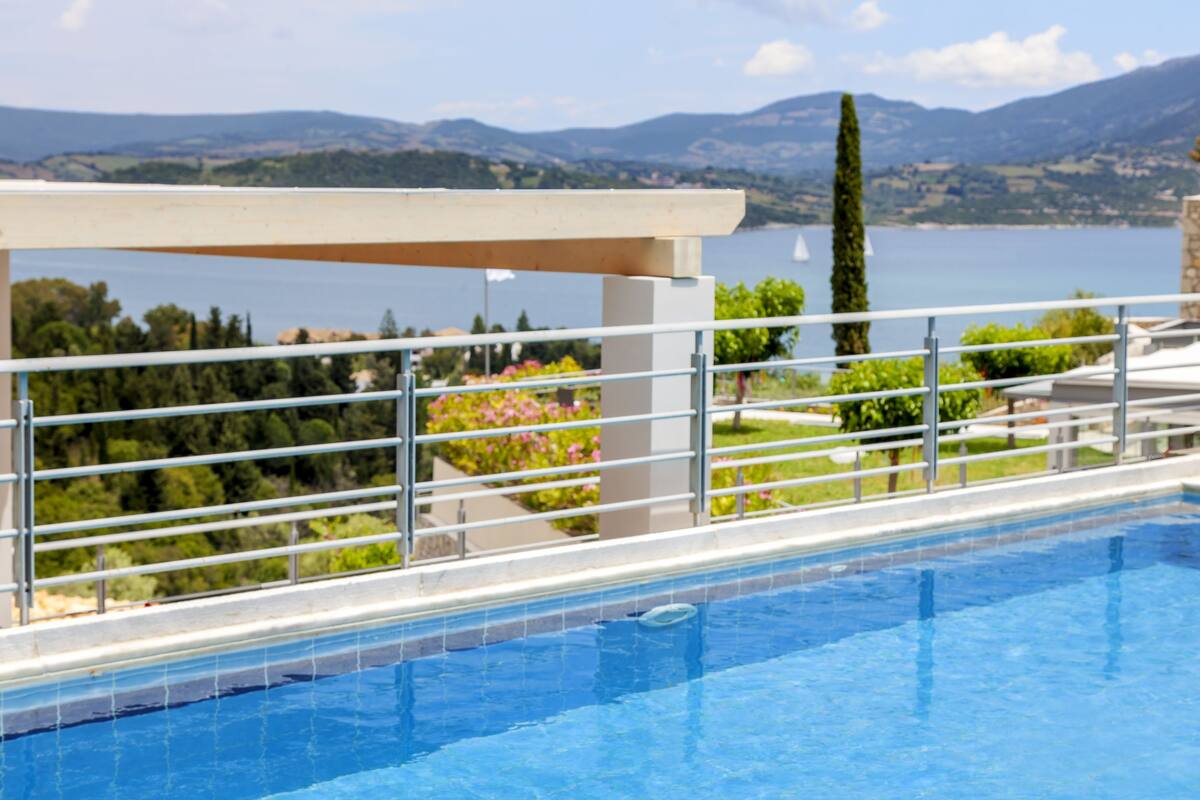 A swimming pool with a view of mountains and a lake.