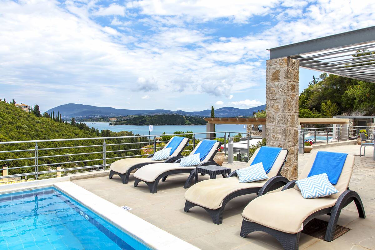A poolside area with lounge chairs and a view of the landscape.