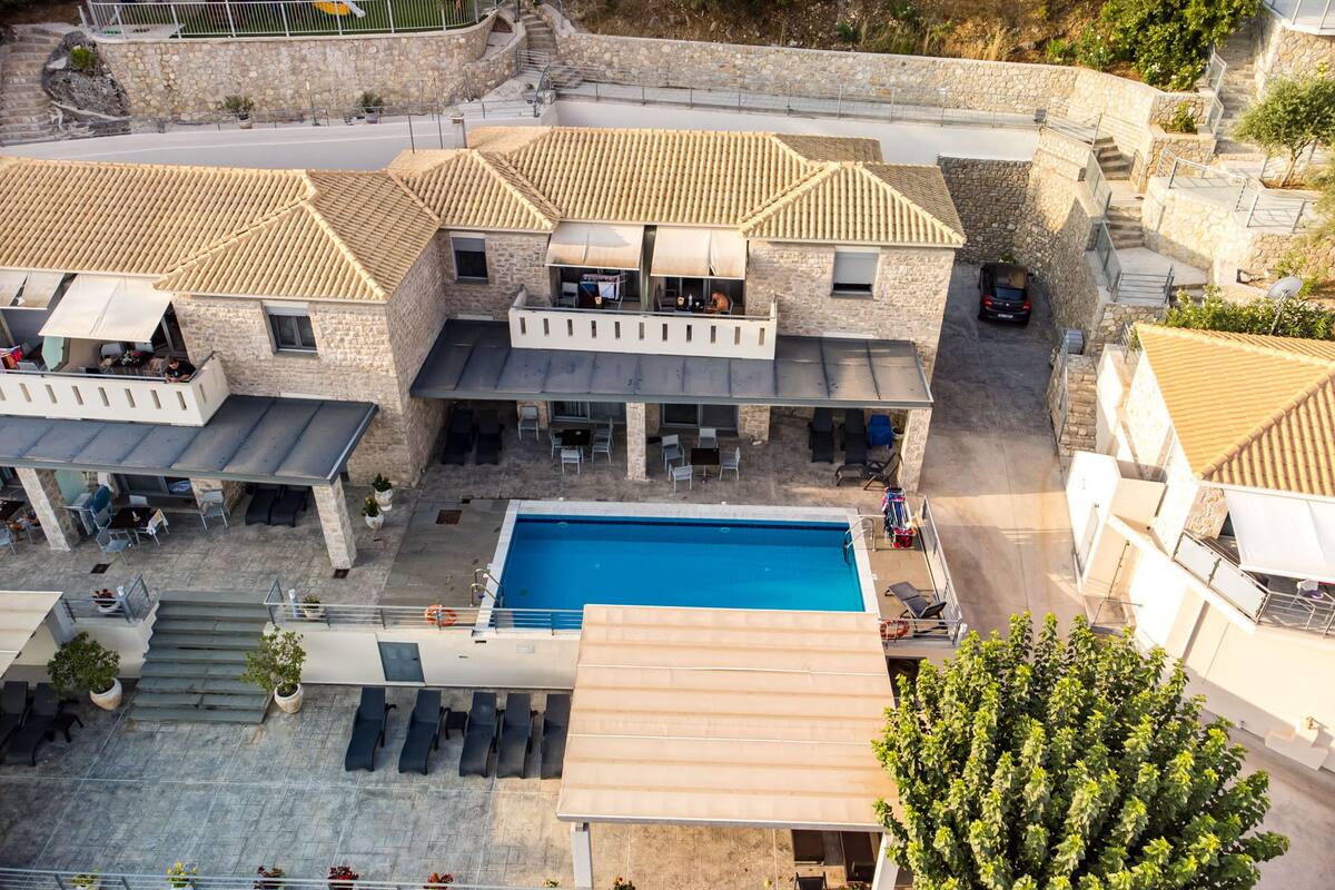 A multi-story building with a swimming pool, outdoor seating, and a playground.