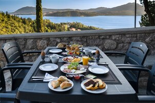 Una mesa dispuesta para el desayuno con una vista panorámica de un lago y montañas.