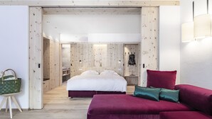 Une chambre moderne avec un grand lit, un canapé rouge et une armoire en bois.