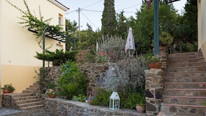 Eine Steintreppe führt zu einem Garten mit Topfpflanzen und einem Laternen.