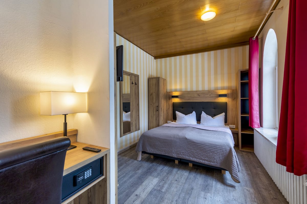 Habitación económica | Escritorio, cortinas blackout y tabla de planchar con plancha 