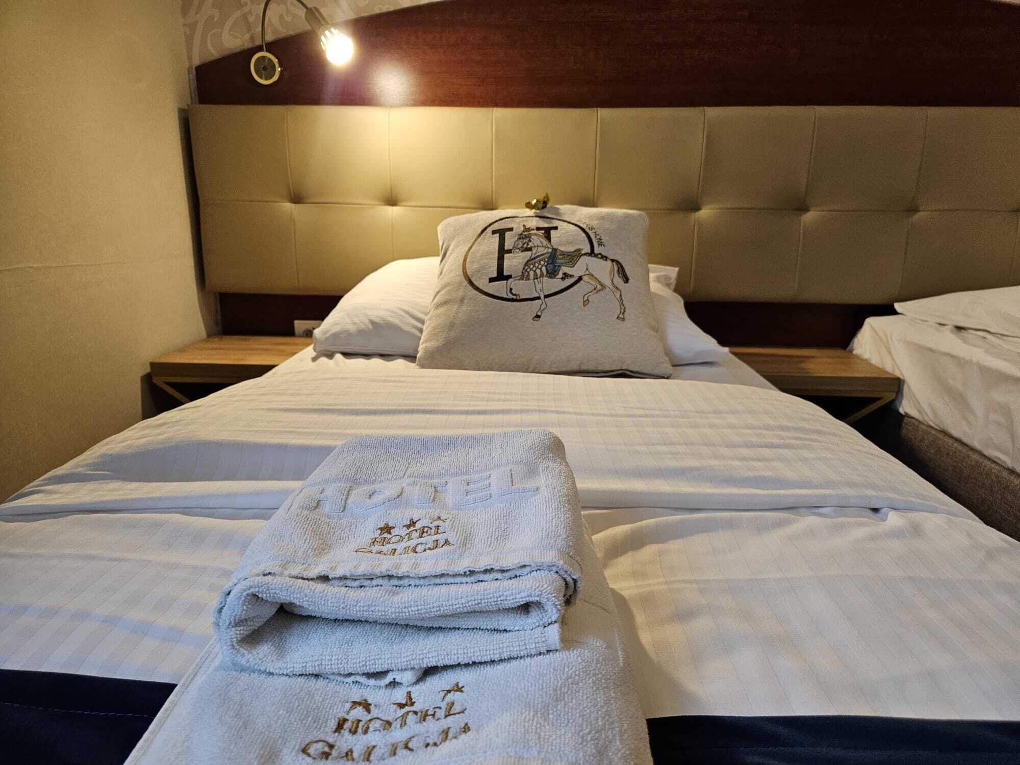 A hotel room with a bed, a headboard, and a nightstand.