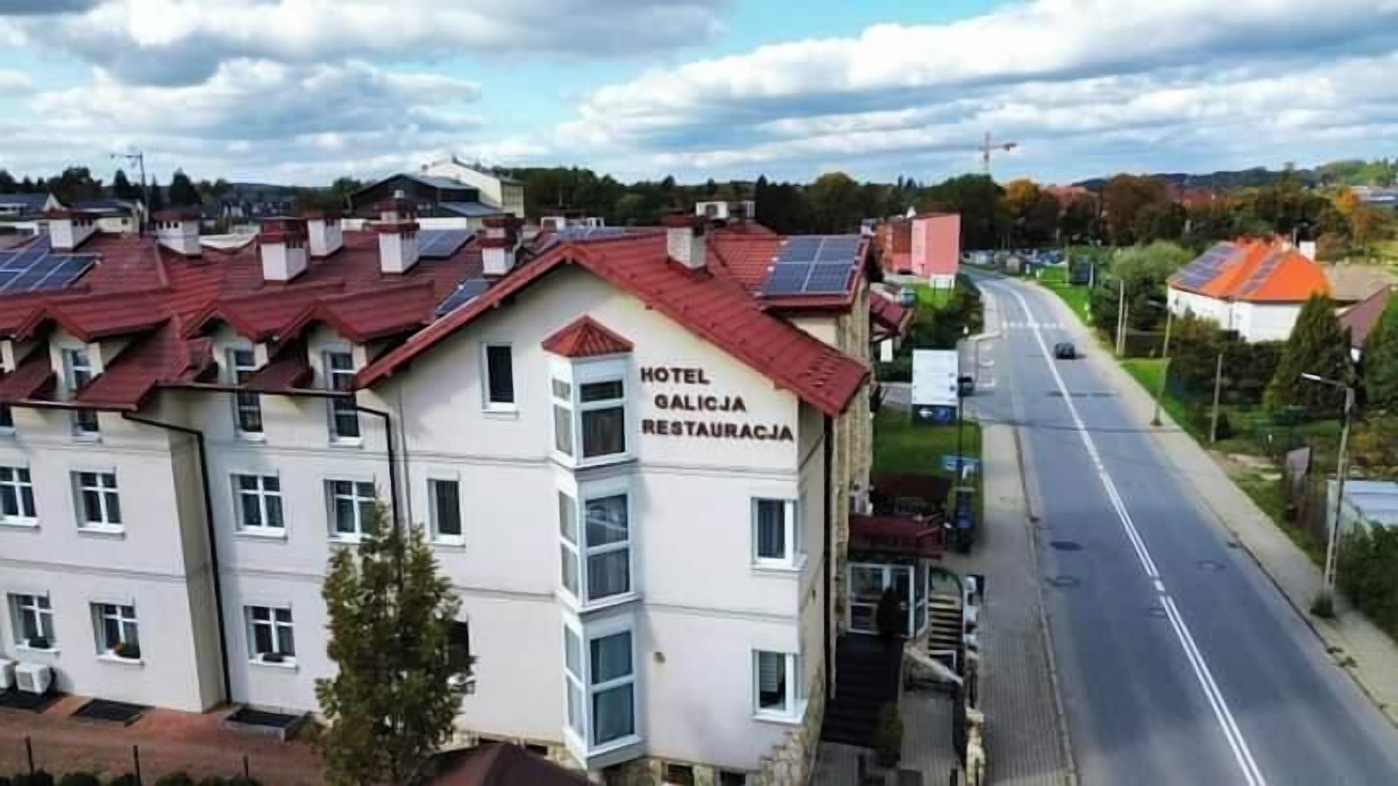 A hotel building with a sign reading "HOTEL GALICJA RESTAURACJA" on the side.