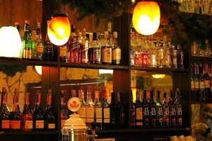 Um bar com prateleiras repletas de garrafas de bebidas.
