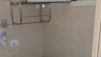 A bathroom with a toilet, bidet, sink, and a hairdryer on a wall.
