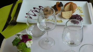 A dining table with a white plate, empty wine glasses, and a green napkin.