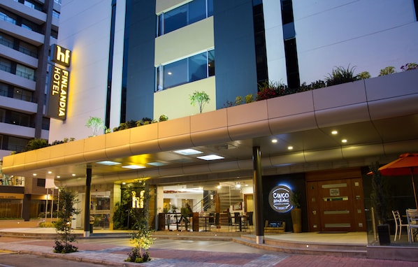 Entrada de hotel con diseño moderno, una escalera visible y un área de estar al aire libre.
