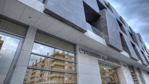 A modern building with large windows and a sign that reads "OPERA HOTEL".