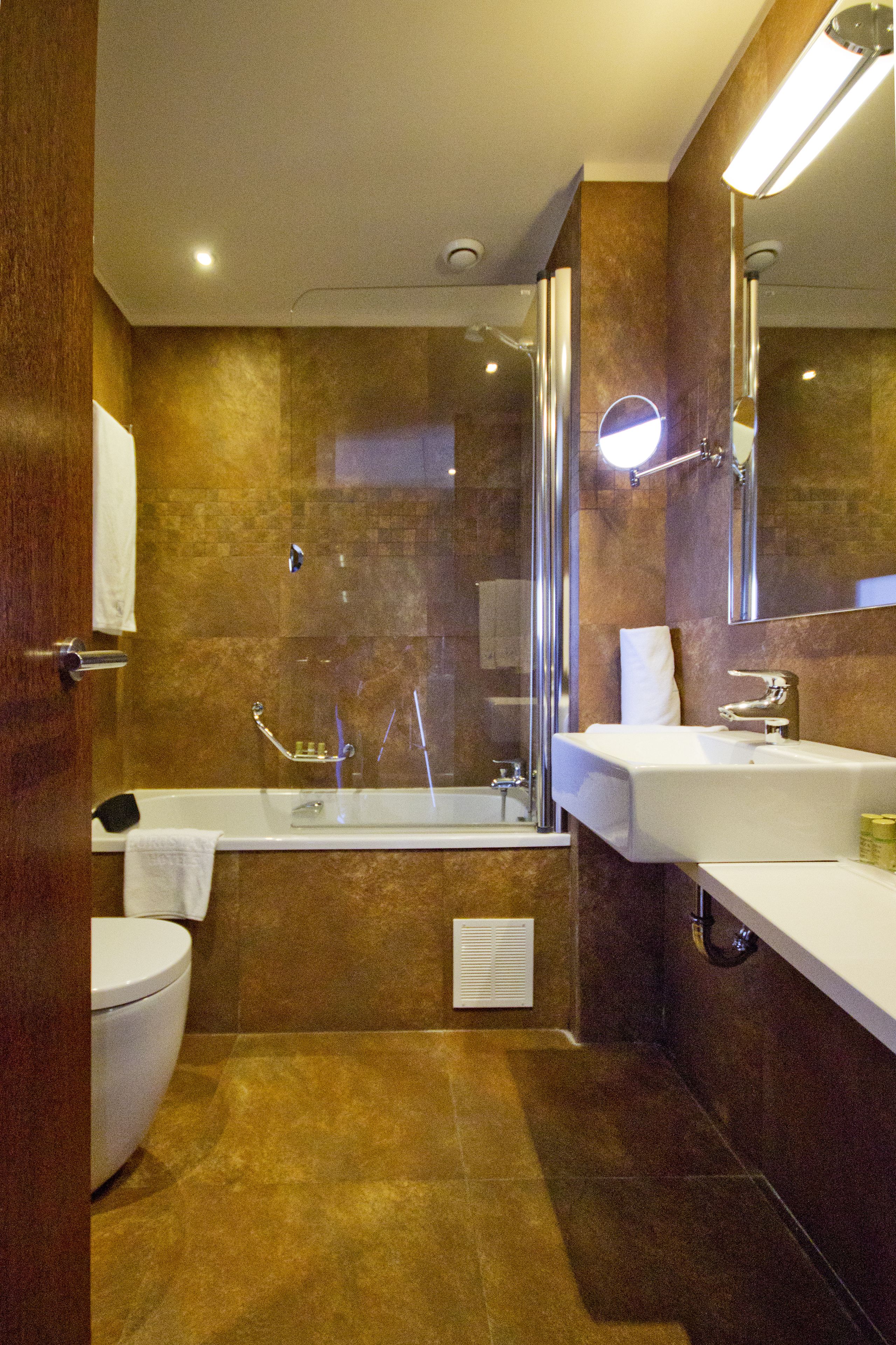 A modern bathroom with a bathtub, a separate shower area, and a vanity with a mirror.