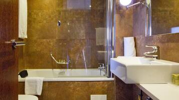 A modern bathroom with a bathtub, a separate shower area, and a vanity with a mirror.
