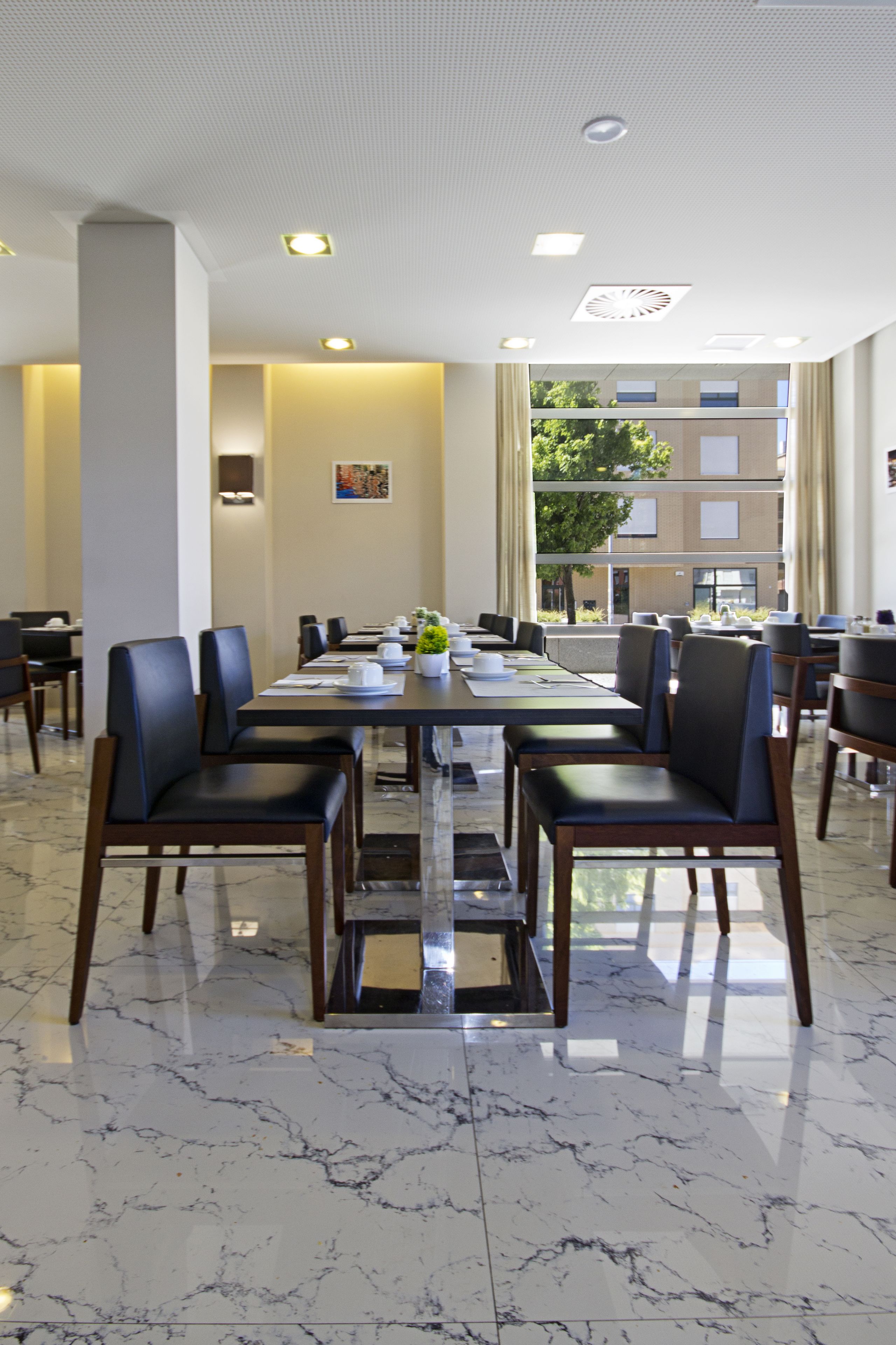Een vergaderzaal met een lange tafel, stoelen en een potplant.