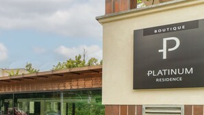A building with a sign reading "BOUTIQUE PLATINUM RESIDENCE."