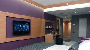 A modern hotel room with a large bed, a TV mounted on the wall, a desk with a chair, and a bathroom visible through an open door. - Met Boutique Hotel - Boutique Class (Izmir)