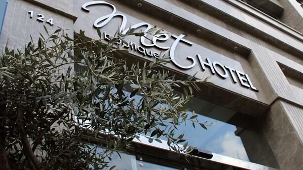 A hotel sign with the name 'Hotel Boutique' and a large tree in front. - Met Boutique Hotel - Boutique Class (Izmir)