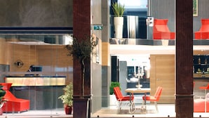 A modern hotel lobby with a reception desk, seating area, and a bar. - Met Boutique Hotel - Boutique Class (Izmir)