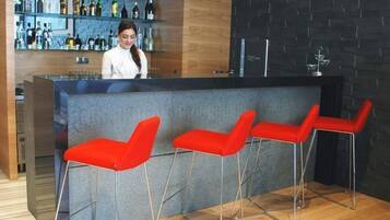Un espace bar avec un comptoir et trois tabourets de bar rouges.