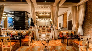 A modern dining area with a central table, cushioned seating, and a decorative centerpiece. - Sofitel Mumbai BKC Hotel (Mumbai)