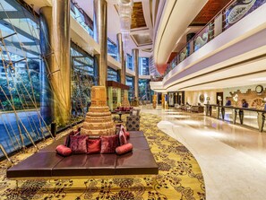 A spacious lobby with a central decorative structure, a seating area with patterned rugs, and a reception desk. - Sofitel Mumbai BKC Hotel (Mumbai)
