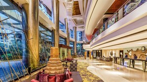 A spacious lobby with a central decorative structure, a seating area with patterned rugs, and a reception desk. - Sofitel Mumbai BKC Hotel (Mumbai)