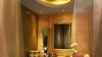 Experience relaxation in this serene spa room, featuring a massage table, vanity, and comfortable seating.