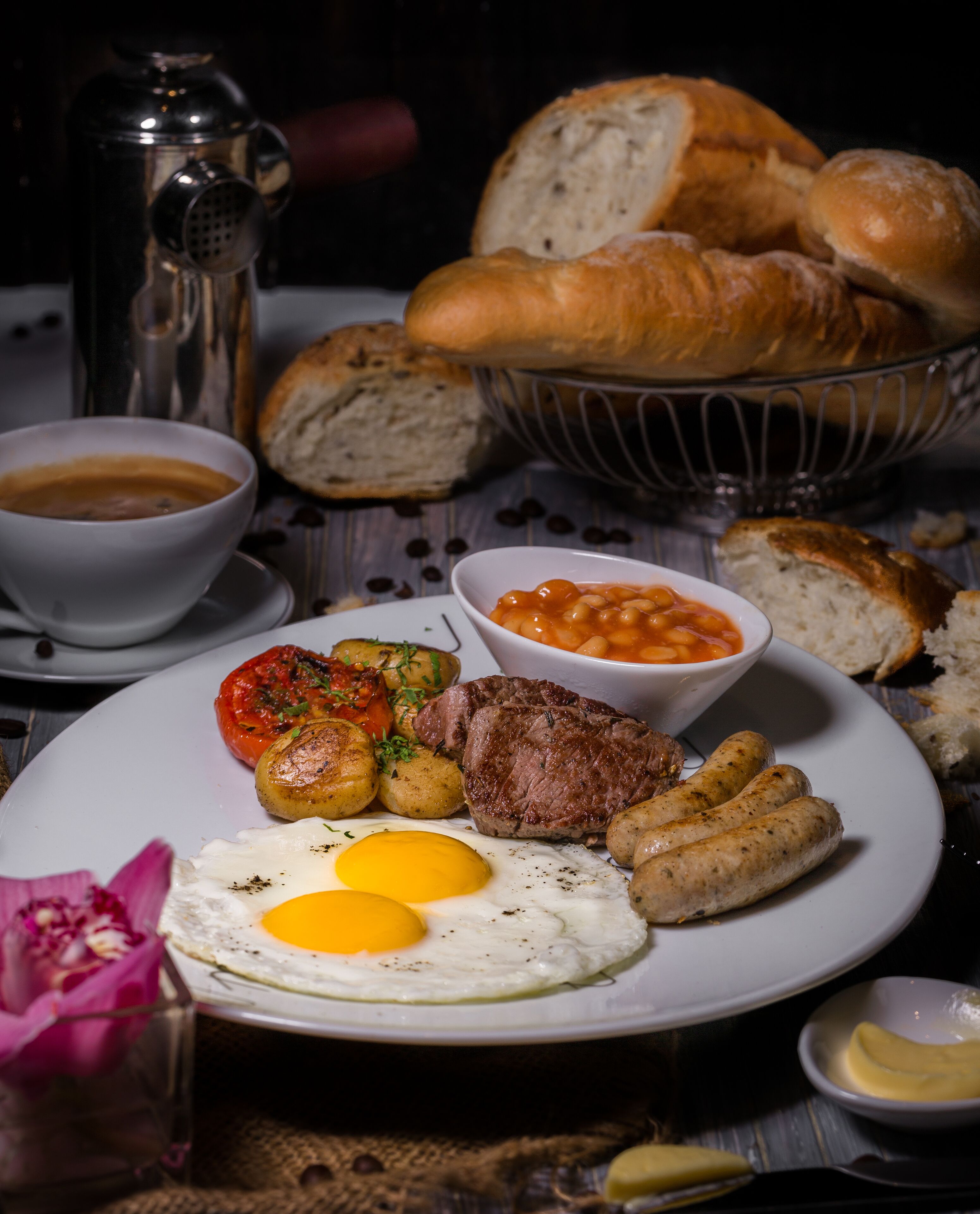 A plate of food including eggs, sausages, steak, and baked beans.
