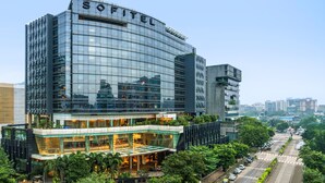 A modern hotel with a glass facade, a prominent 'SOFITEL' sign, and a landscaped courtyard. - Sofitel Mumbai BKC Hotel (Mumbai)