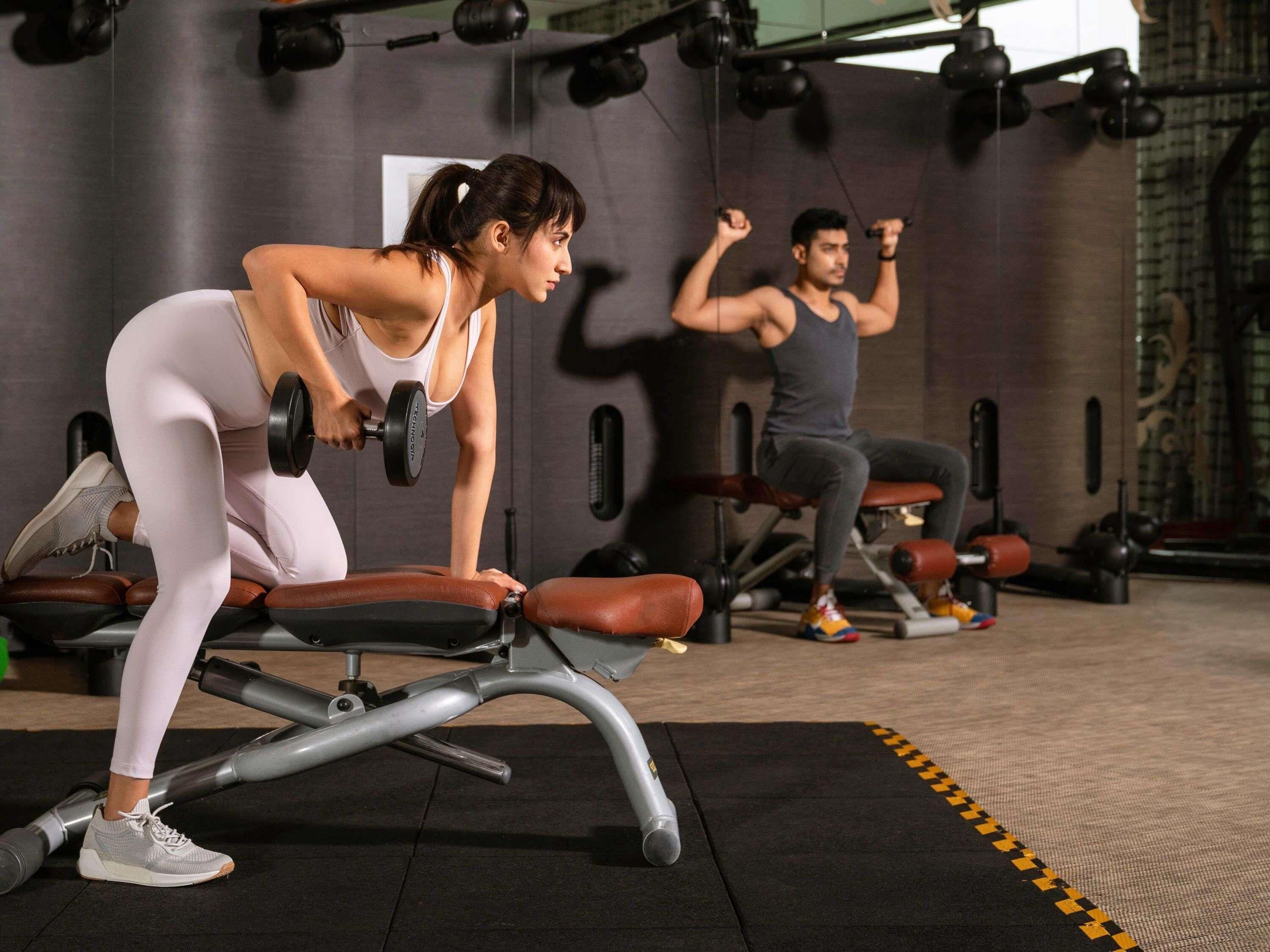 A gym with exercise equipment, including dumbbells and benches.
