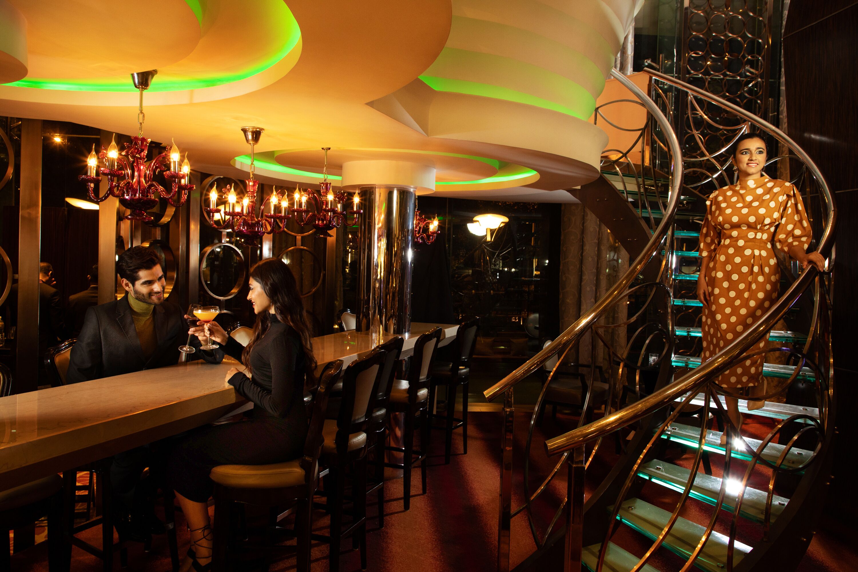 A restaurant with a modern interior, a bar area, and a spiral staircase.