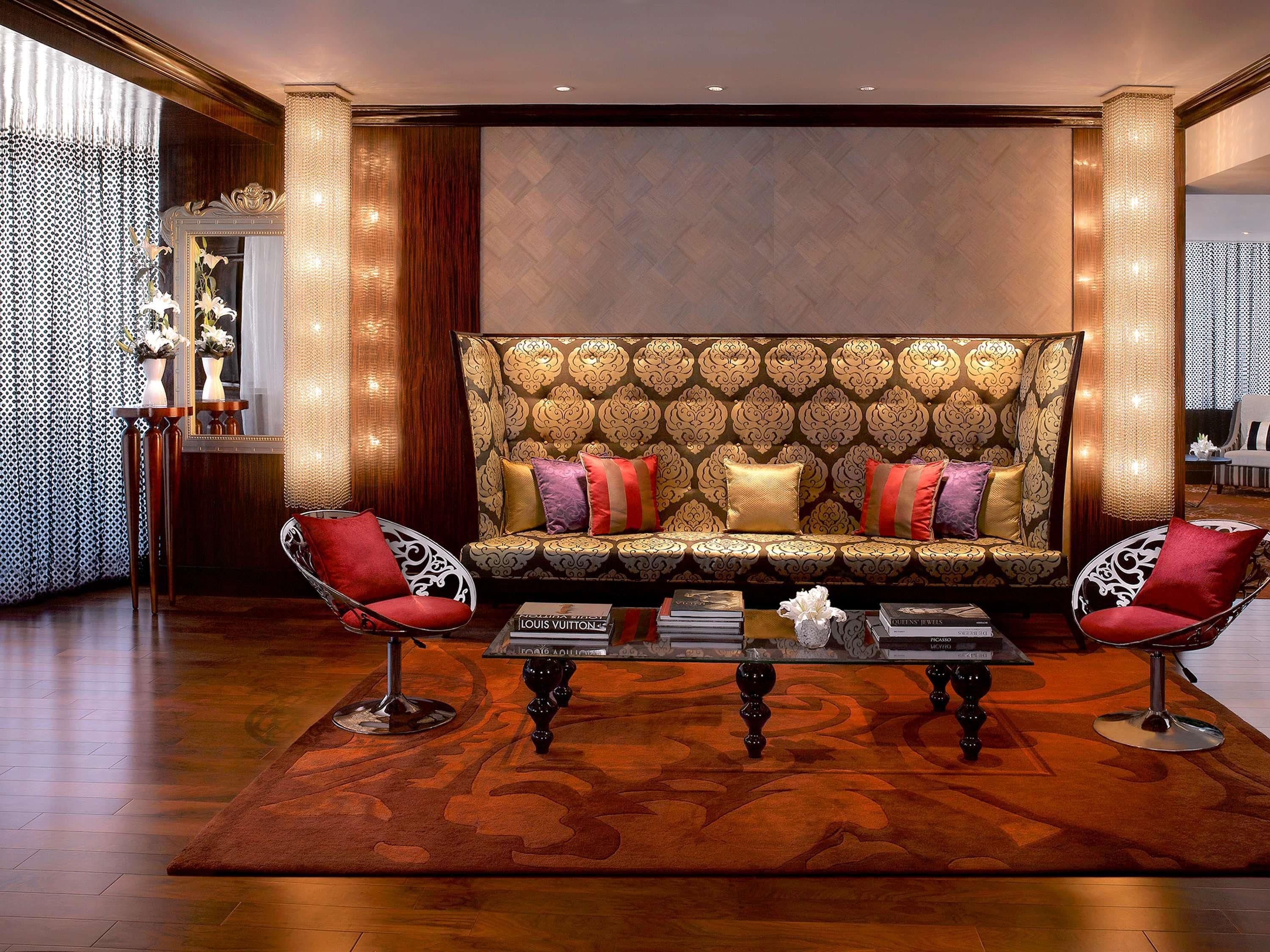 A luxurious living room with a patterned sofa, two armchairs, and a coffee table.